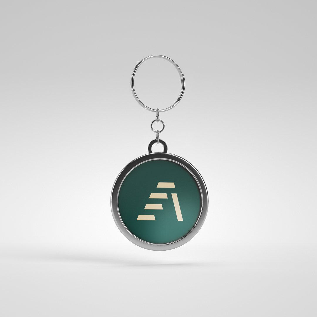 Metal keyring with the Attain Wealth Advisory mark in green