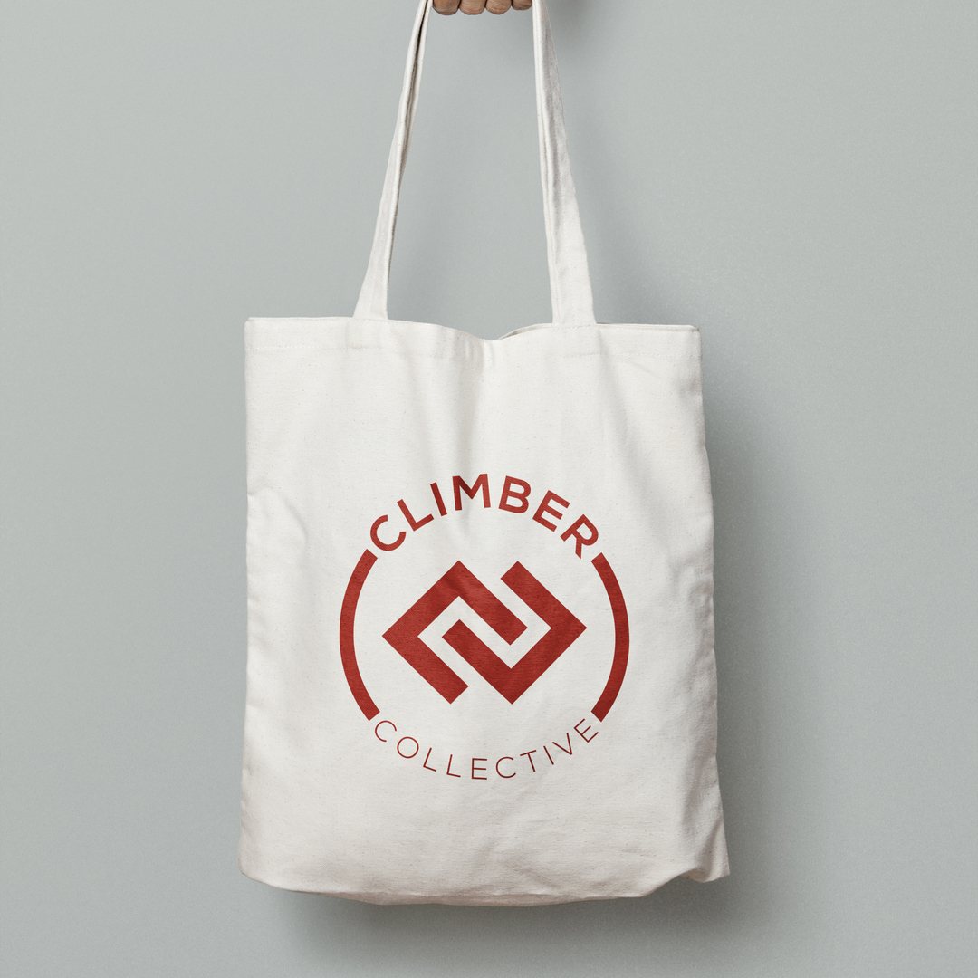 Canvas tote bag printed with the Climber Collective circular logo in red