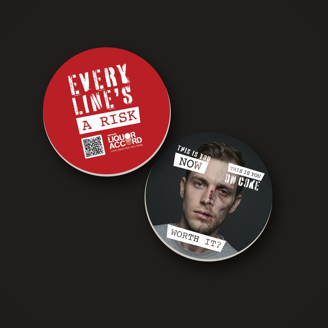 Round coasters printed with the campaign logo, a QR code and a bruised face