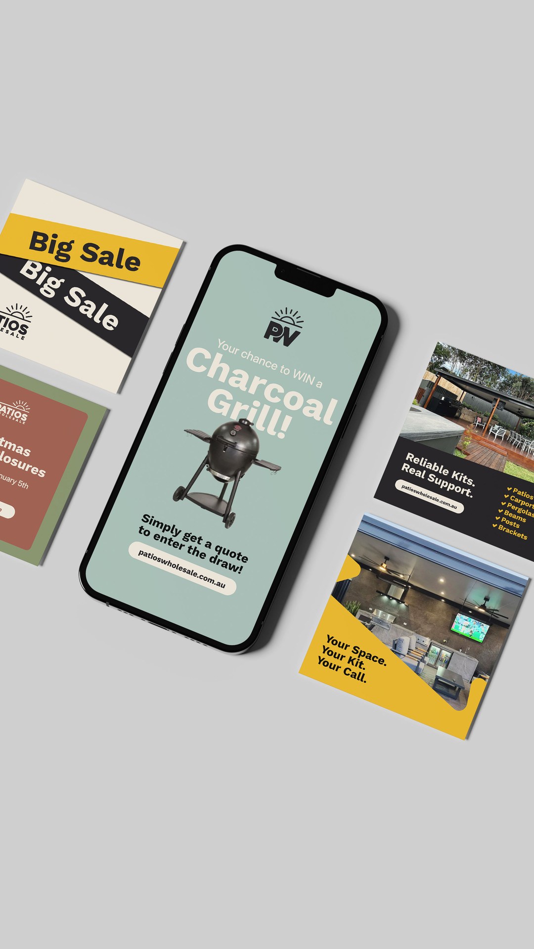 Patios Wholesale sale posters and a phone showing a charcoal grill giveaway